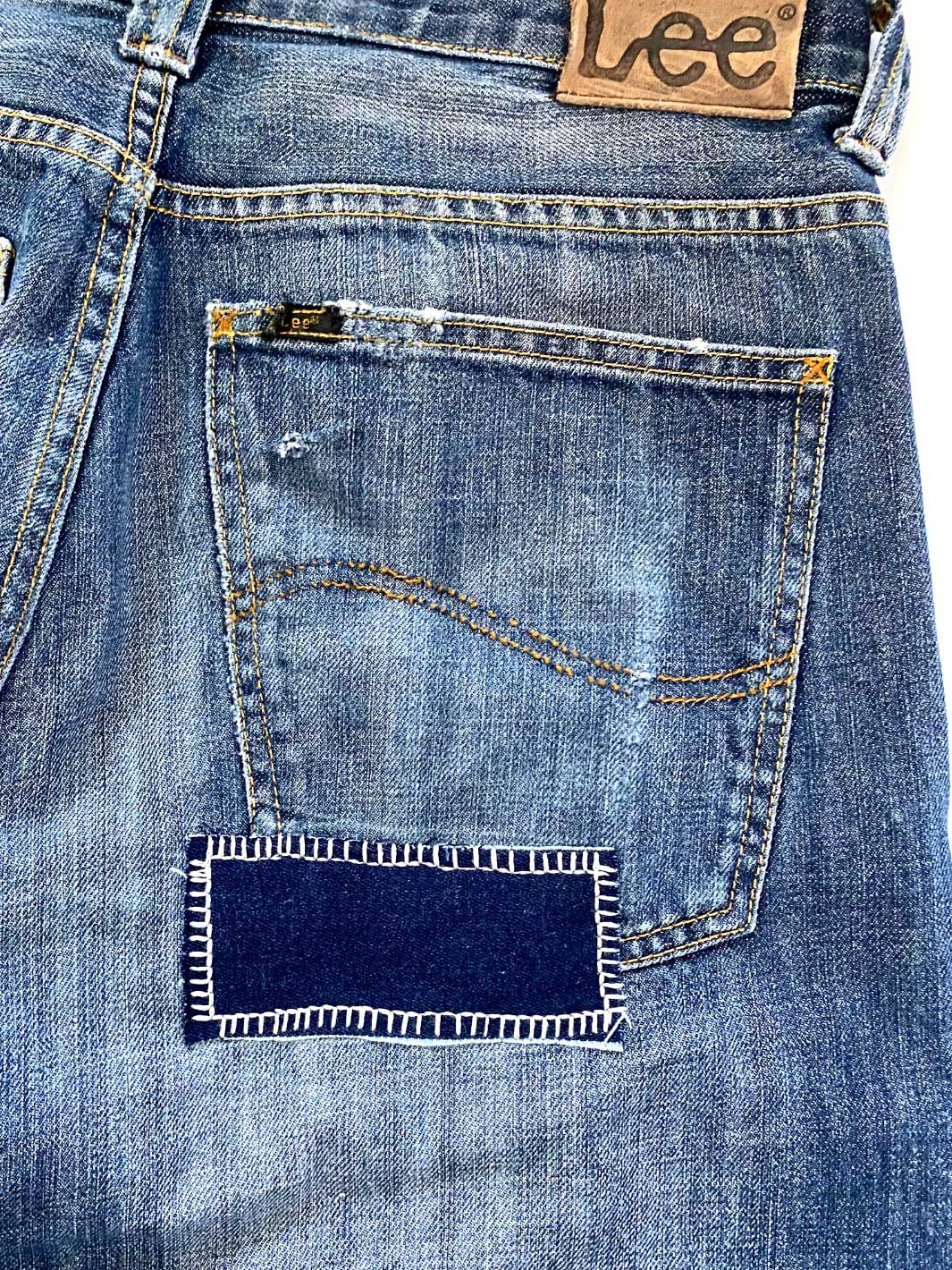 Herren Vintage Denim mittelblaue Waschung Größe 31/32 repariertes Loch mit dunkelblauen Jeans Stoff an hinterer rechter Gesässtasche 100% Baumwolle