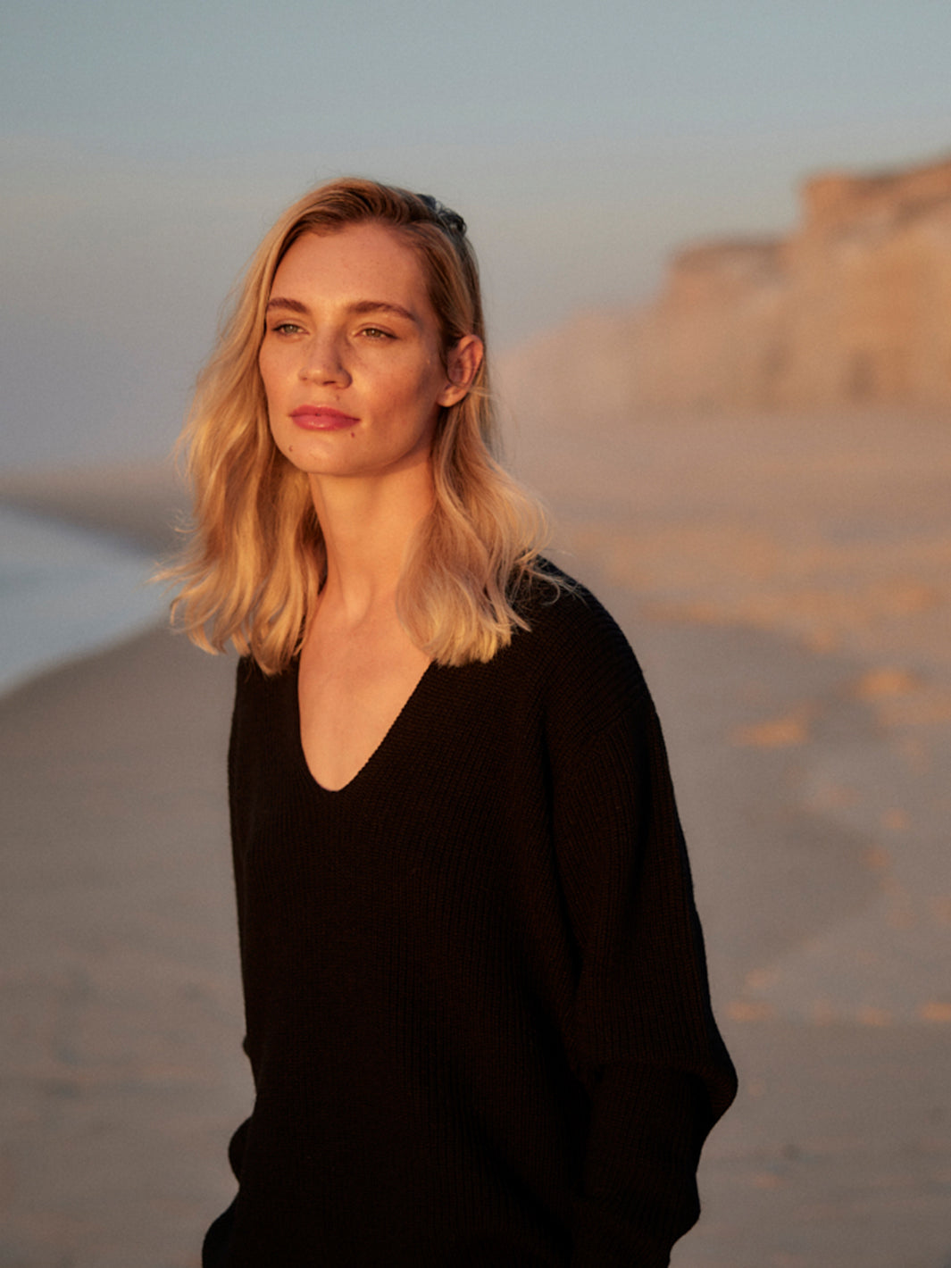 Damen Strick Pullover mit V-Ausschnitt aus Wolle in Schwarz von WOTE - fair und nachhaltig in Italien produziert, Anschnitt Bild