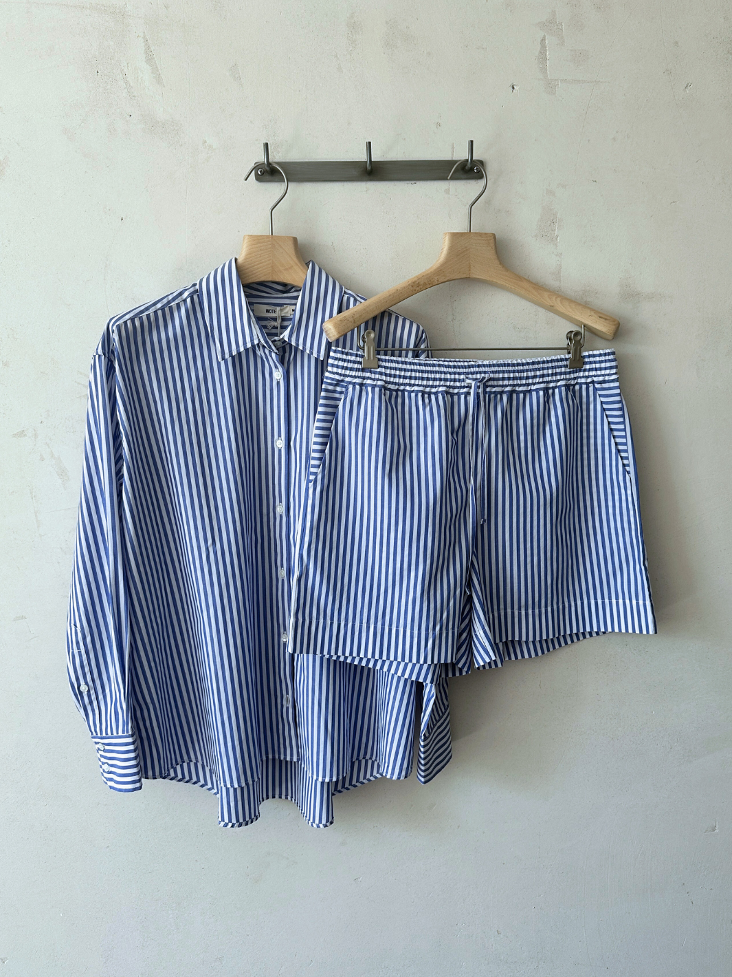 Nachhaltige Damen Bermuda Shorts in Blau-Weiß aus Bio-Baumwolle von WOTE - made in Portugal ( Shorts mit Bluse hängend auf Bügel Frontansicht)