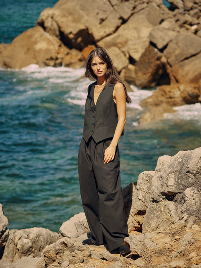 Damen Weste in Schwarz aus nachhaltiger Wolle von WOTE - made in Portugal ( Model stehend mit langer Hose Frontansicht)