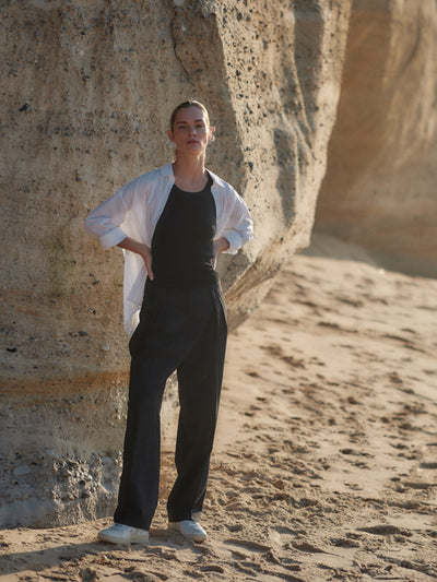 Damen Wollhose in schwarz aus nachhaltiger Wolle, bequeme Passform von WOTE - fair und nachhaltig in Portugal gefertigt, Frontansicht mit weißer Bluse