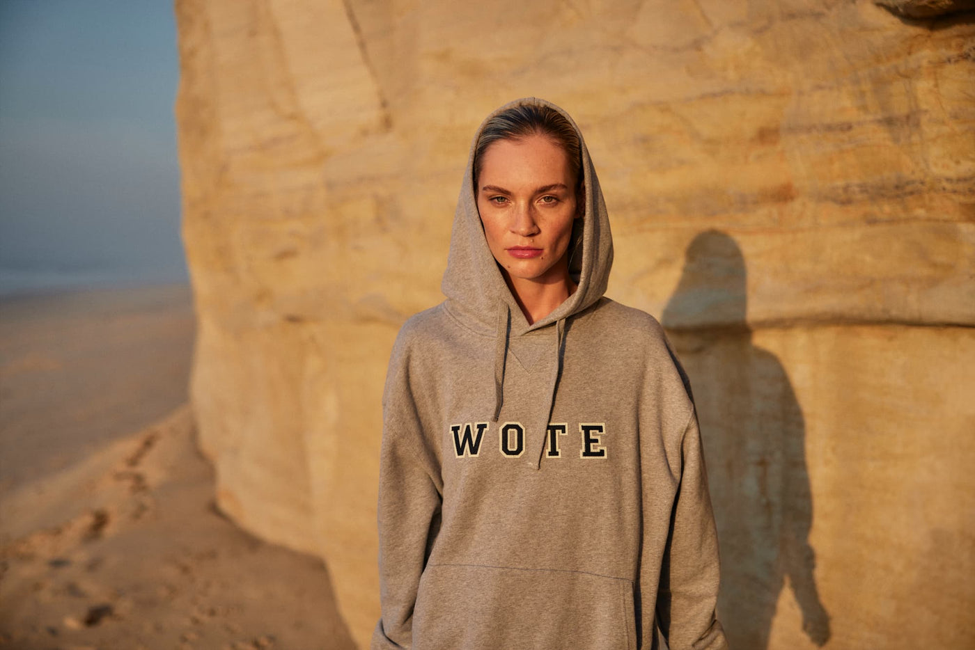 WOTE Damen Hoodie in Grau – Editorial-Aufnahme im warmen Sonnenlicht am Strand