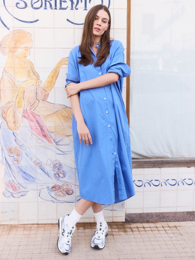 Model trägt ein blaues Midi-Hemdblusenkleid aus Organic Cotton.
