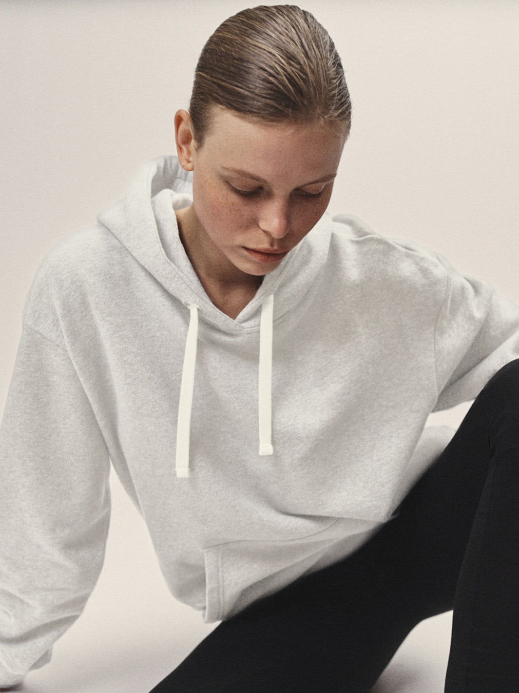 Damen Hoodie Sweatshirt in Off-White aus weicher Bio-Baumwolle in Off-White von WOTE - Fair und Nachhaltig in Portugal produziert,Frontansicht Model sitzend