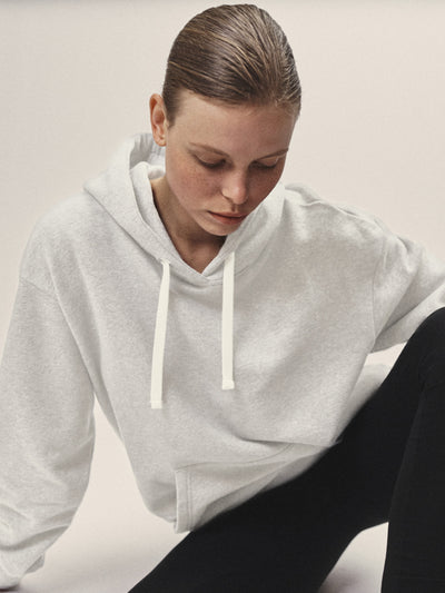 Damen Hoodie Sweatshirt in Off-White aus weicher Bio-Baumwolle in Off-White von WOTE - Fair und Nachhaltig in Portugal produziert,Frontansicht Model sitzend