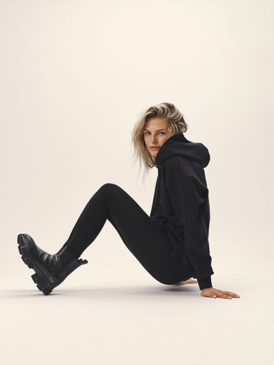 Damen Hoodie Sweatshirt in schwarz aus Bio-Baumwolle von WOTE - made in Portugal, Seitenansicht Model sitzend