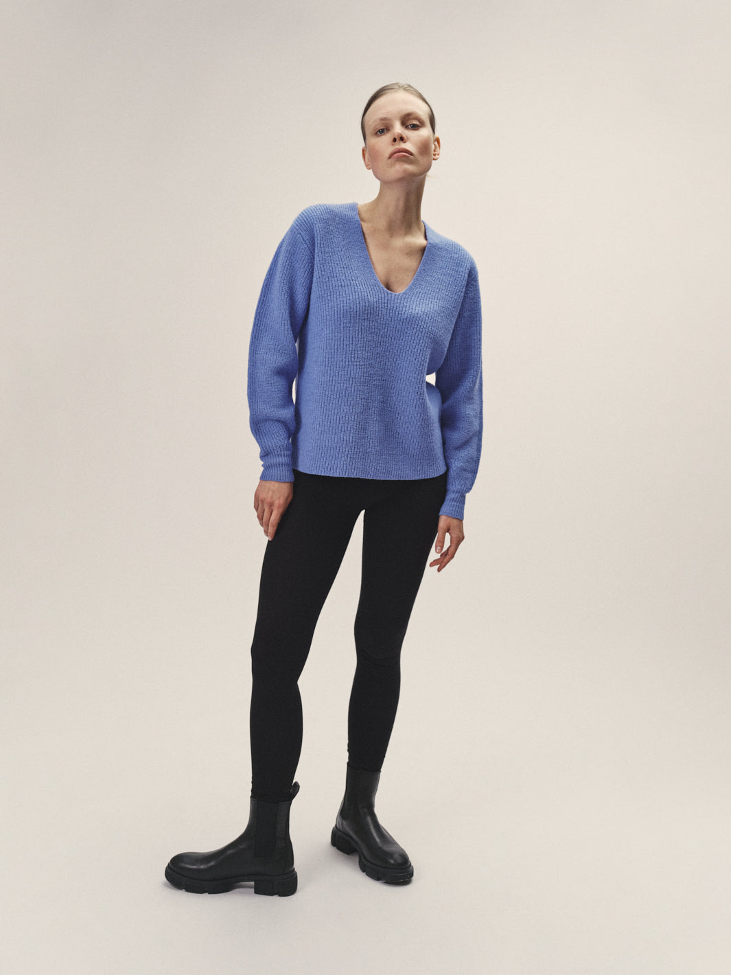 Damen Strick Pullover mit V-Ausschnitt in Blau aus nachhaltiger Merino Wolle von WOTE - fair in Italien produziert, Frontansicht, Model stehend