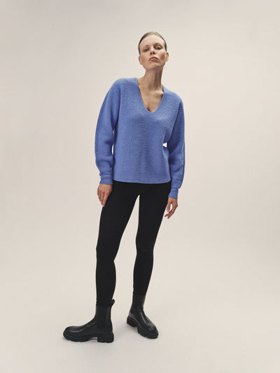 Damen Strick Pullover mit V-Ausschnitt in Blau aus nachhaltiger Merino Wolle von WOTE - fair in Italien produziert, Frontansicht, Model stehend
