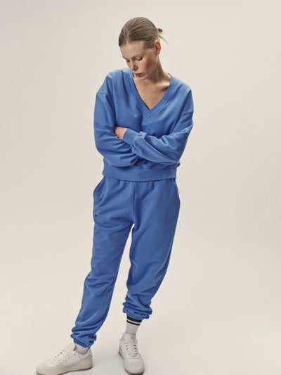 Damen Sweatshirt mit V-Neck in blau aus reiner Bio-Baumwolle von WOTE - produziert in Portugal, Frontansicht Model mit verschränkten Armen
