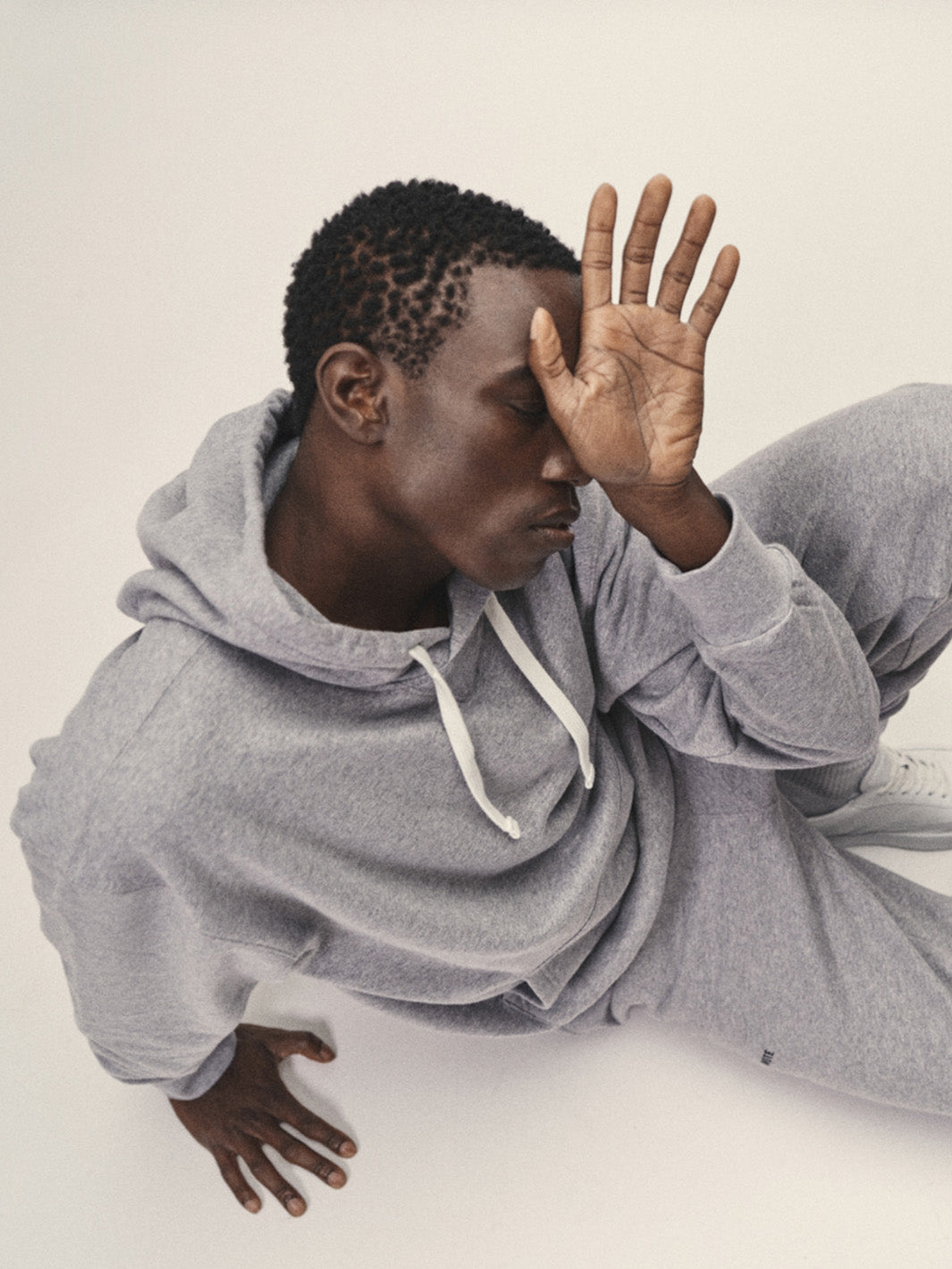 Männer Hoodie Sweatshirt in Grau-Melange aus Bio-Baumwolle in Portugal produziert von WOTE - Model sitzend