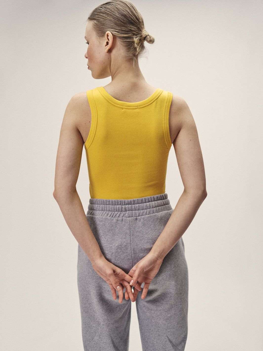 Damen Tank Top Rippe in Gelb aus 96% Bio-Baumwolle mit 4% Elasthan von WOTE - fair und nachhaltig in Portugal produziert, Rückenansicht Model im Studio